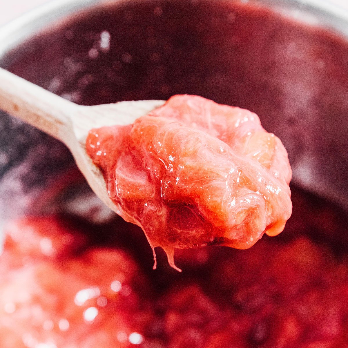 Rhubarb compote on a wooden spoon.