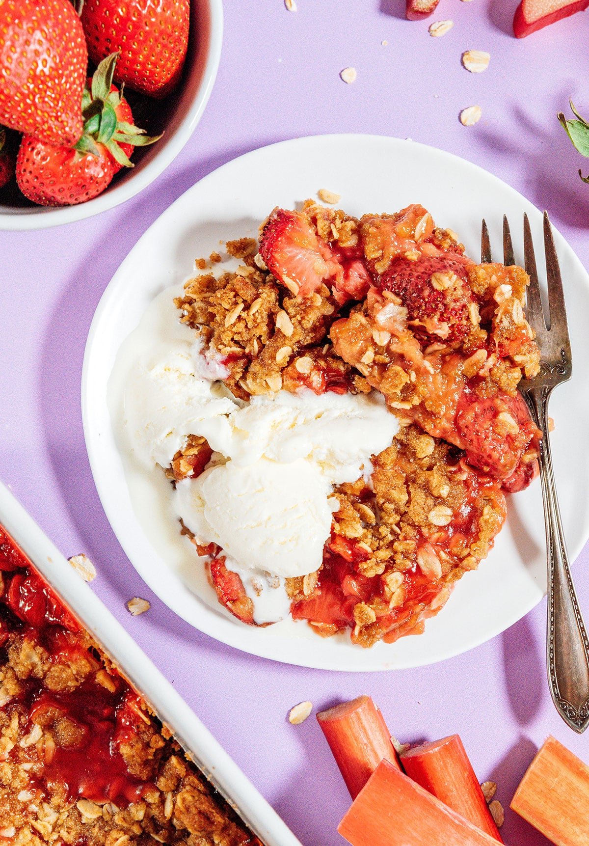 Rhubarb crisp with ice cream on a plate with a fork