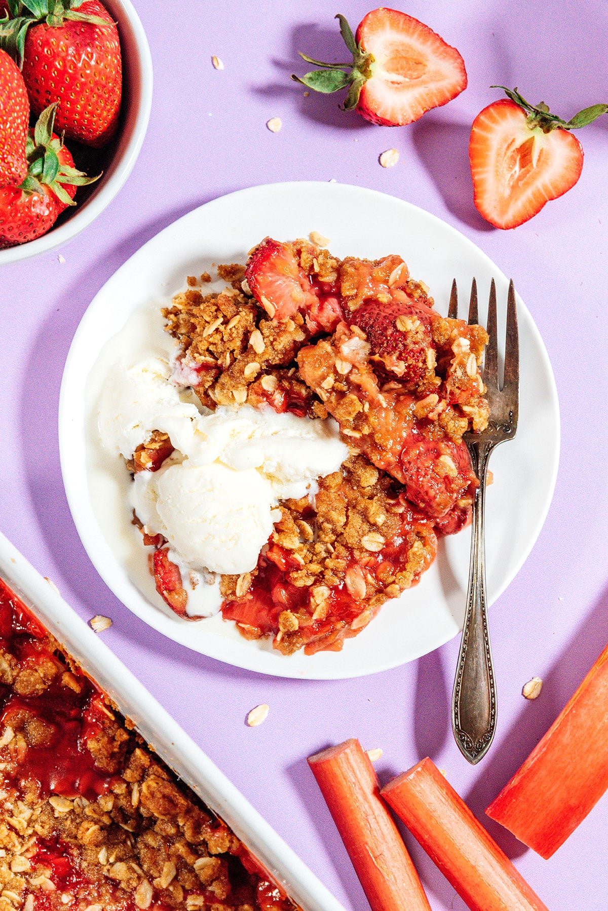 Rhubarb crisp with ice cream on a plate with a fork