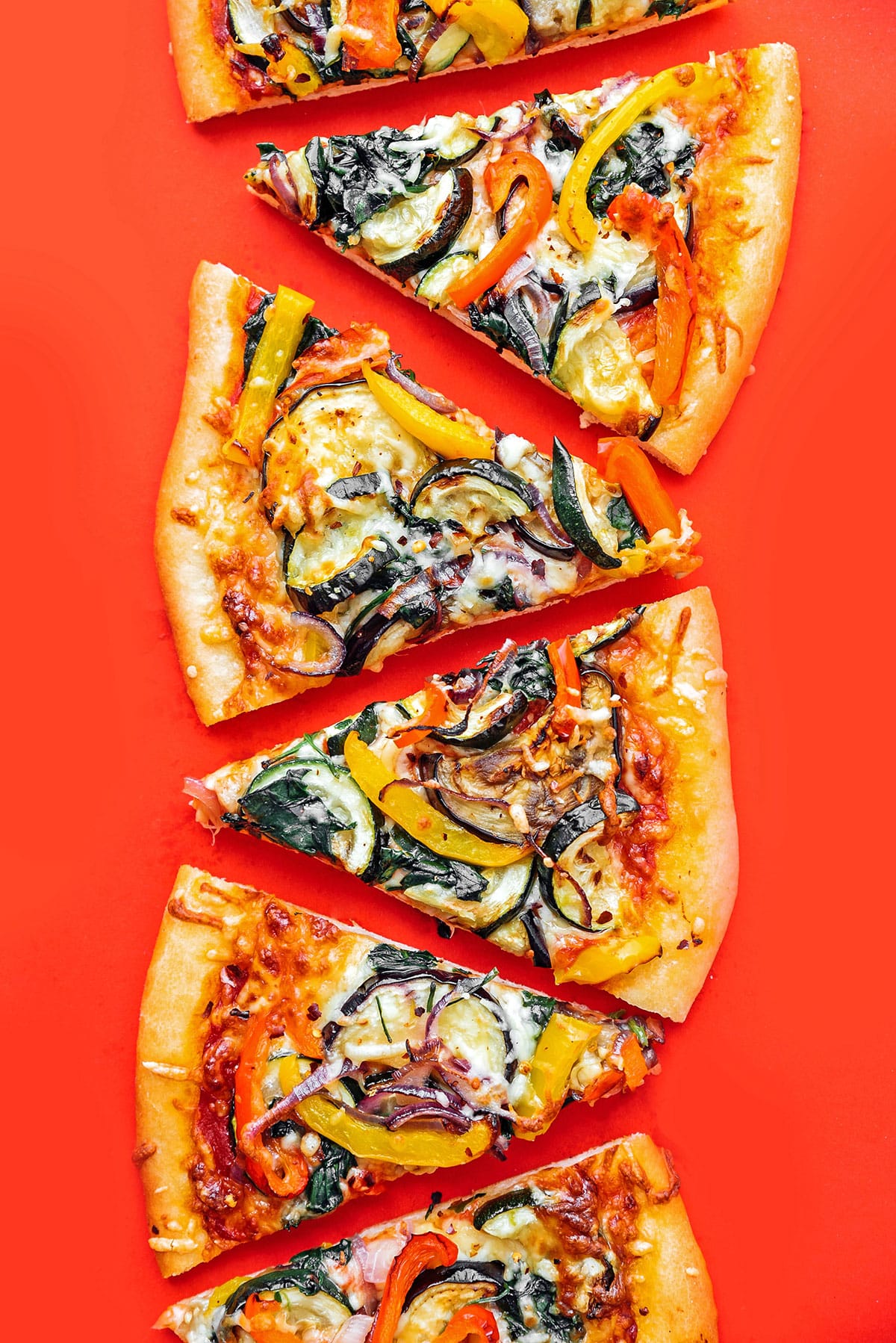 Veggie pizza on a red background.