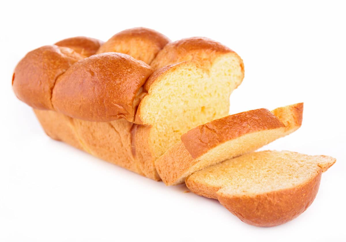 Sliced brioche bread on white background.