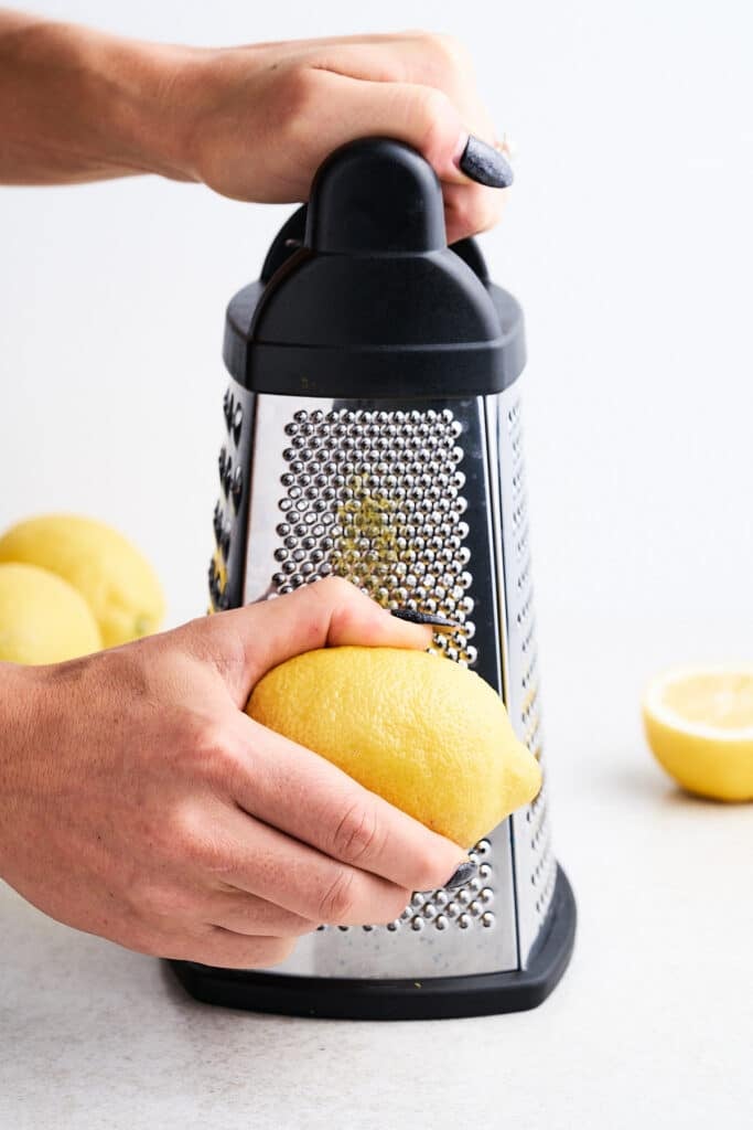 Zesting lemon on a box grater.