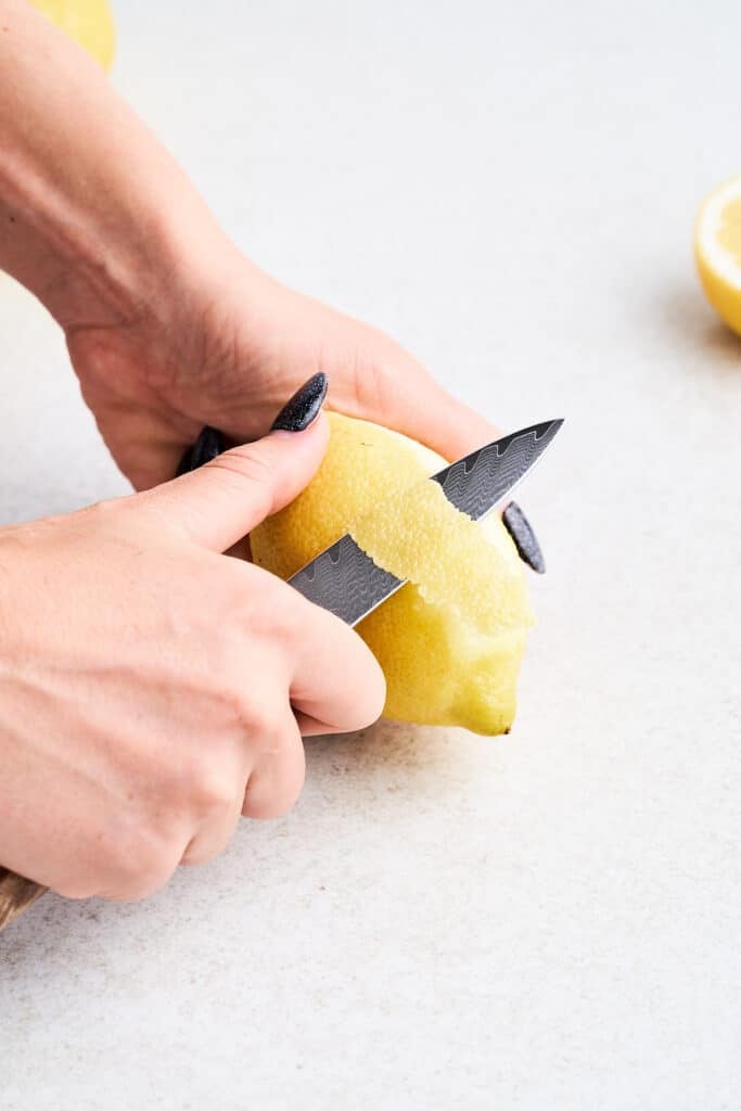 Zesting lemon with a knife.