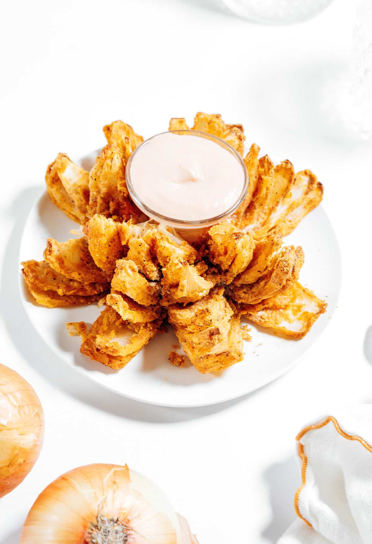 Air fryer bloomin onion on a white plate.