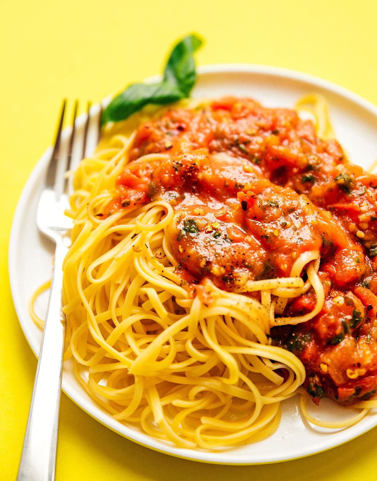Homemade marinara sauce on a plate of spaghetti.