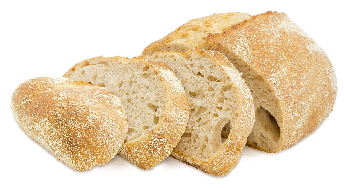 Sliced sourdough bread on white background.