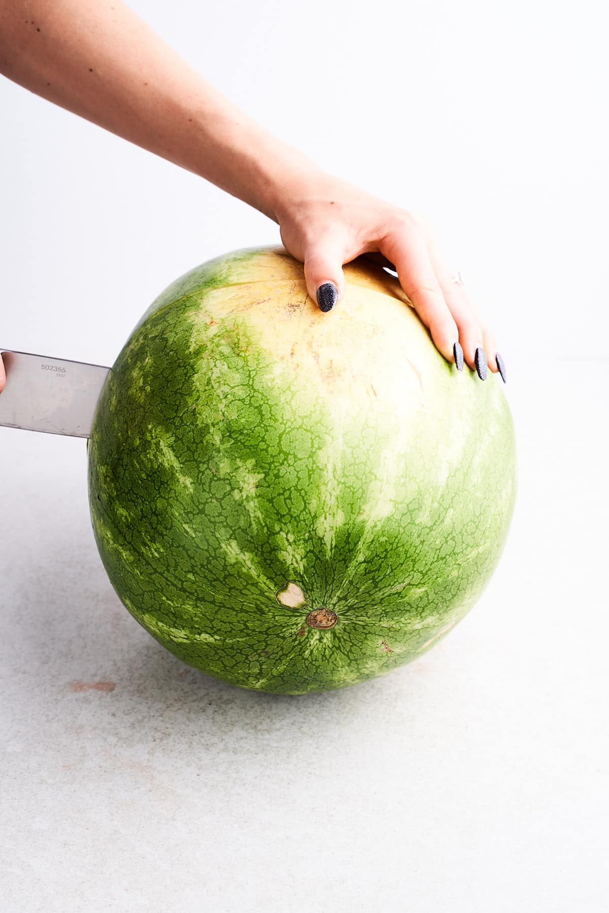 Cutting a watermelon in half.
