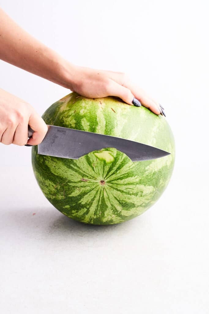 Trimming the end off a watermelon.