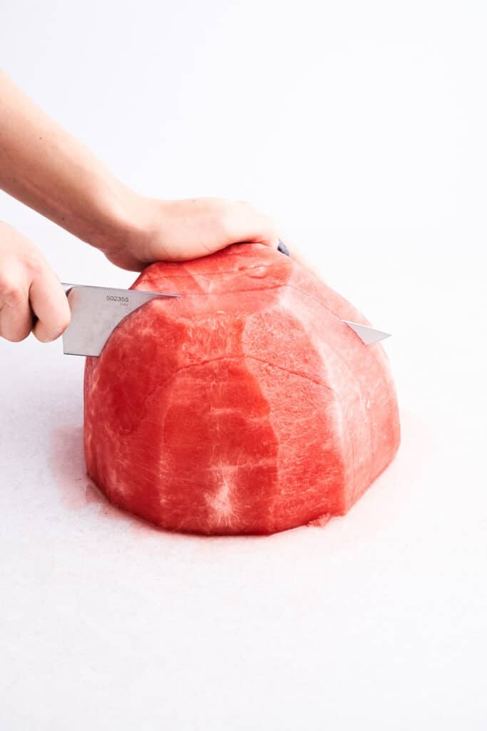 Slicing a peeled watermelon.