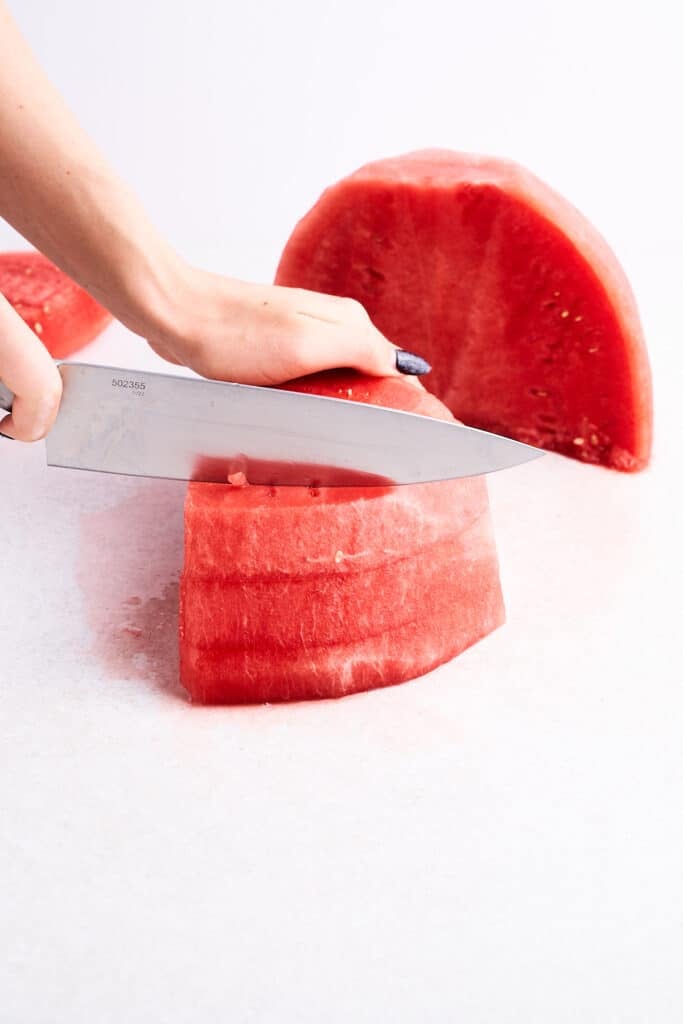 Slicing a watermelon into strips.