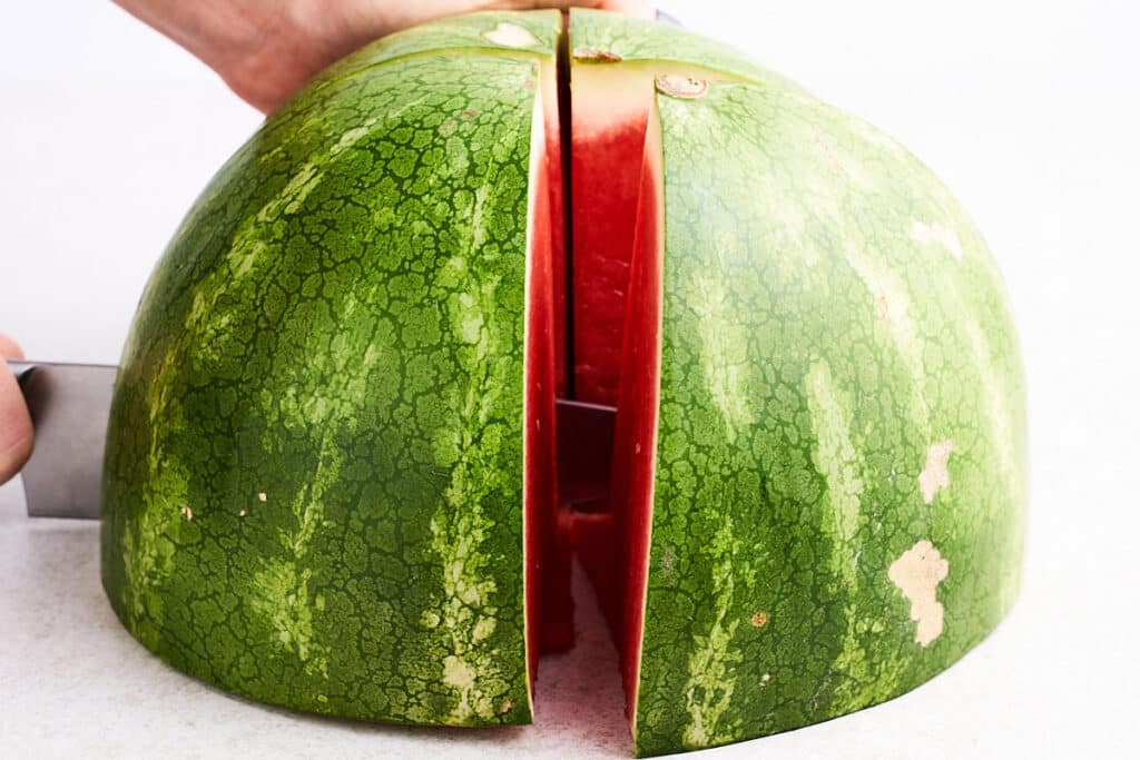Cutting watermelon in quarters.