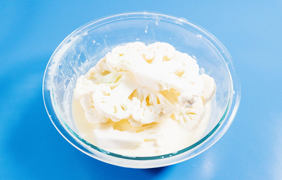 Cauliflower in a bowl of buttermilk.