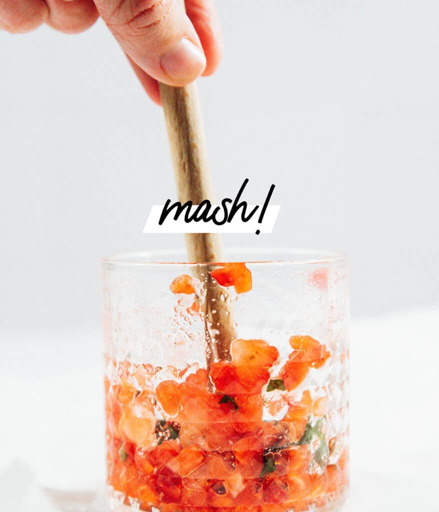 Mashing fruit in a glass for mojtos.
