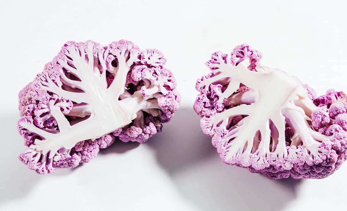 Purple cauliflower halves on a white background.