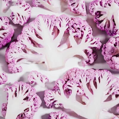 Purple cauliflower slices on a white background.