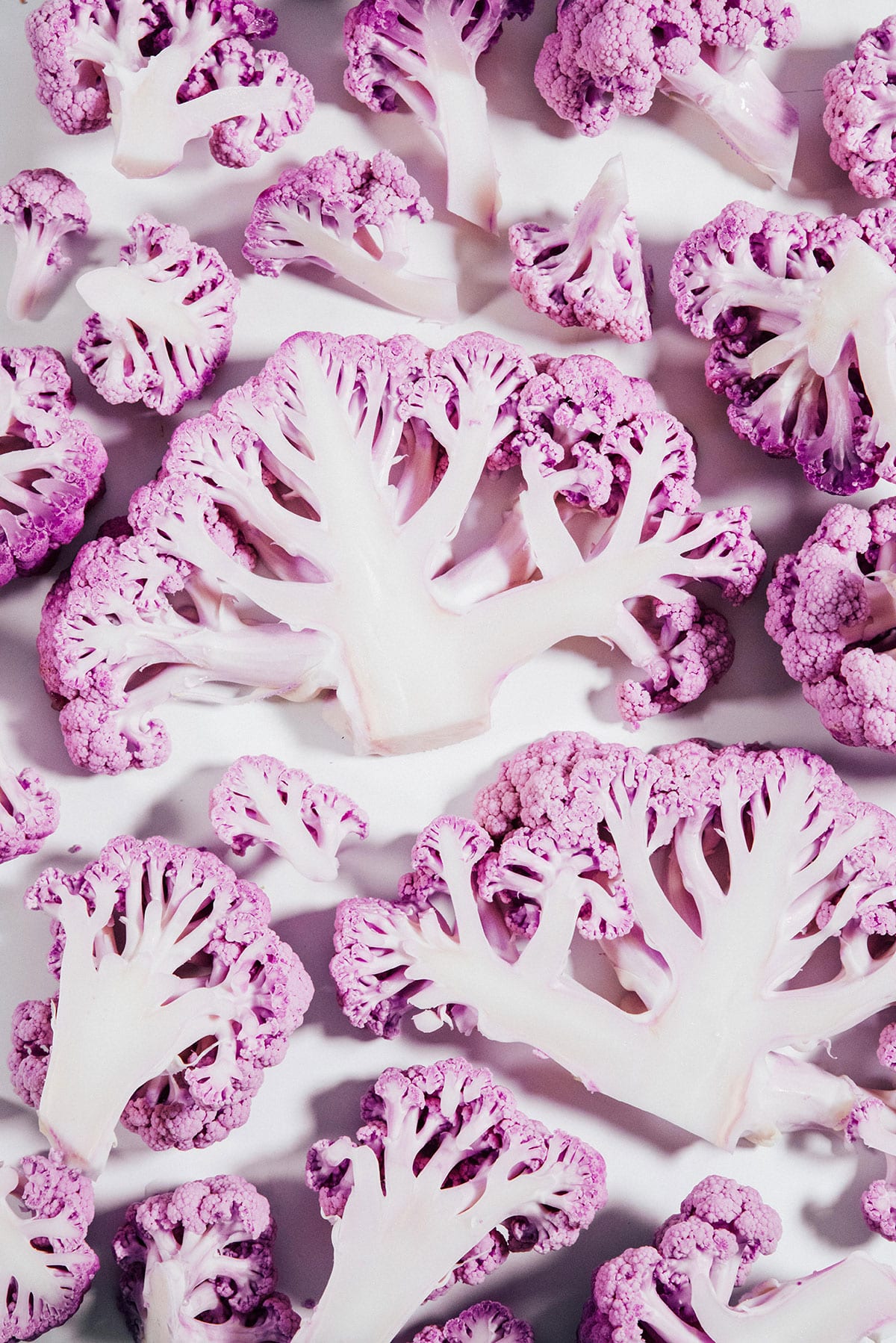 Purple cauliflower slices on a white background.