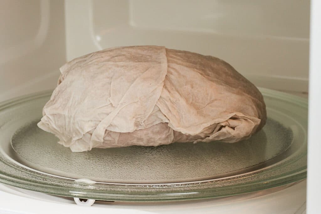 Sweet potato wrapped in paper towel in the microwave.