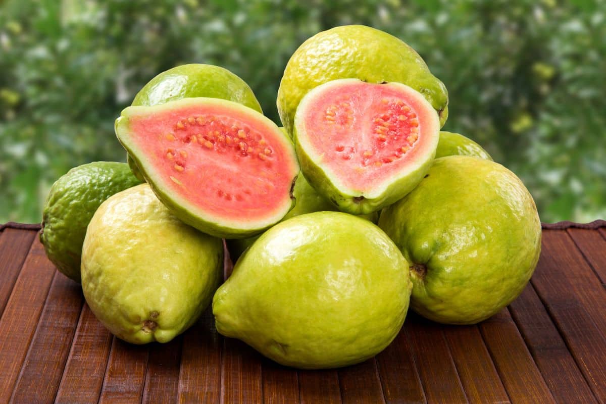 Brazilian guava stacked up on a wood table.