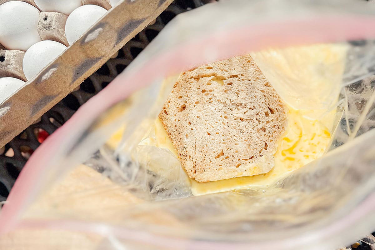 Bread soaking in eggs in a bag.