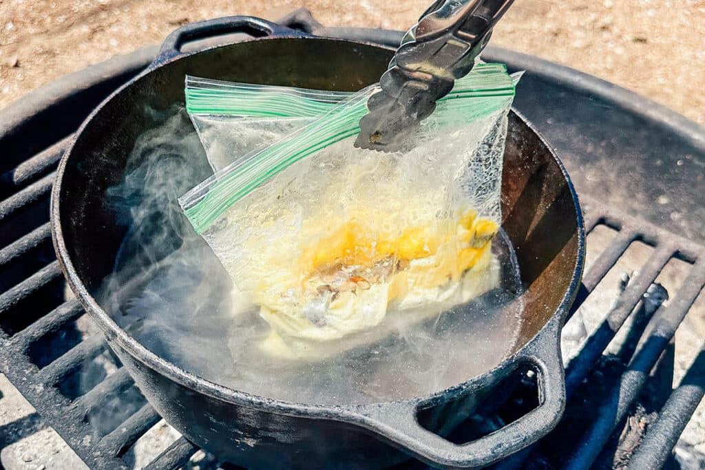 Dipping eggs in bags into hot water.