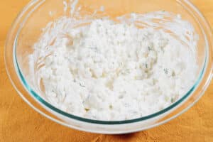 Ingredients to make cottage cheese salad on a yellow tablecloth.