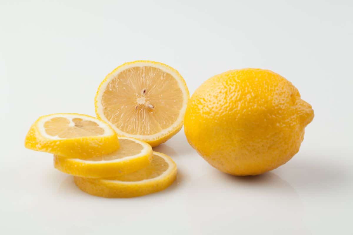 Limone di rocca imperiale on a white background with one sliced open.