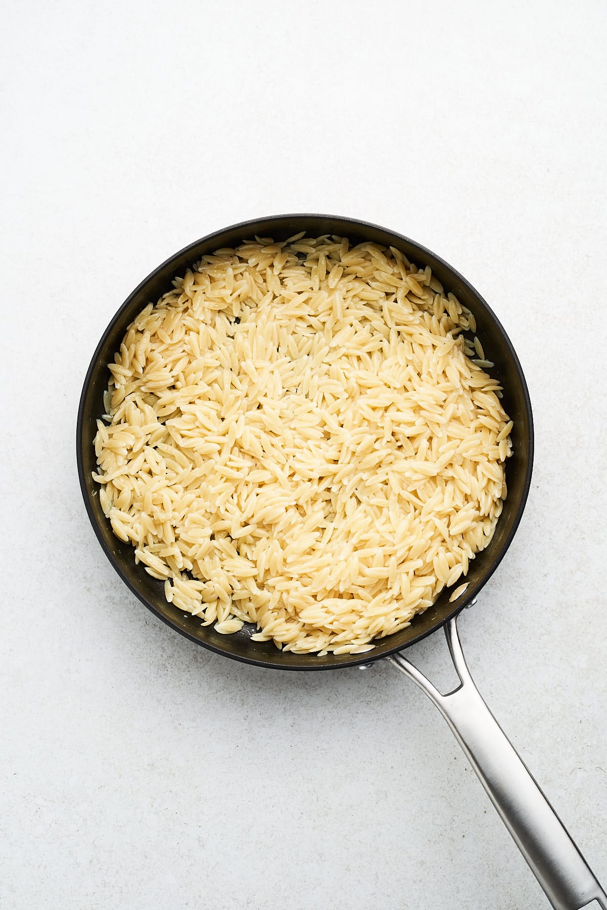 Cooked orzo in a pan.