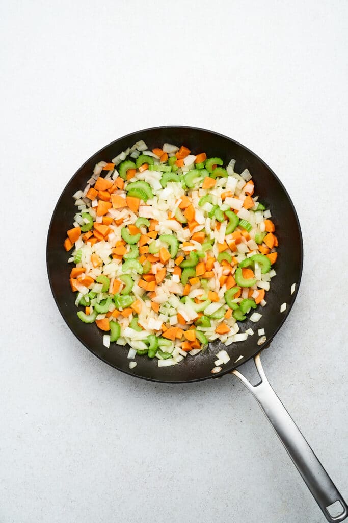 Cooked mirepoix in a pan.