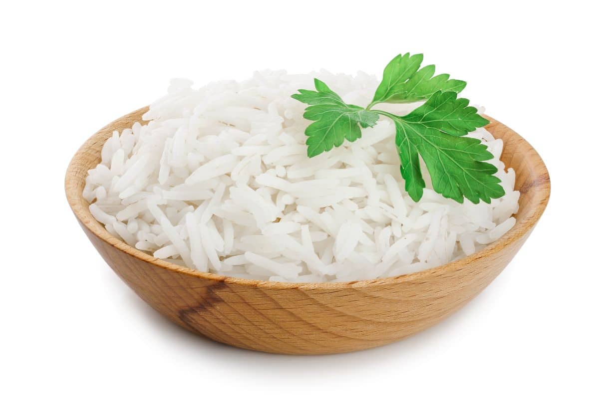 Basmati rice in a wood bowl on a white background.