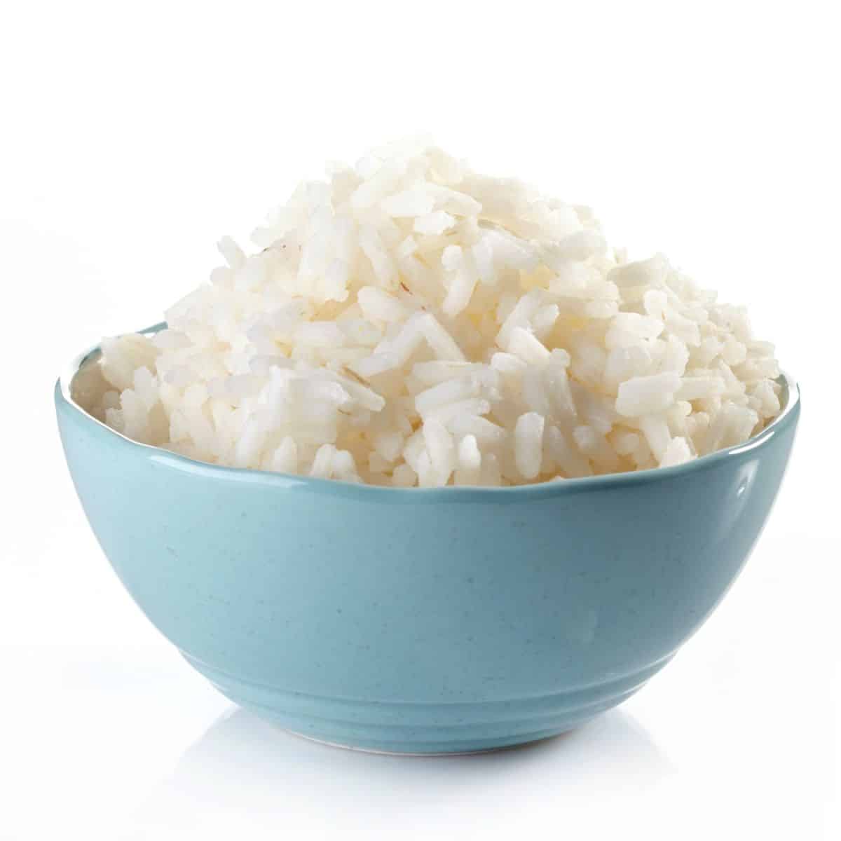 Bhutanese white rice in a blue bowl on an isolated white background.