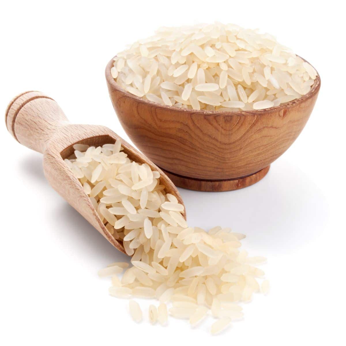 California blonde rice in a wood bowl next to a wood spoon on a white background.