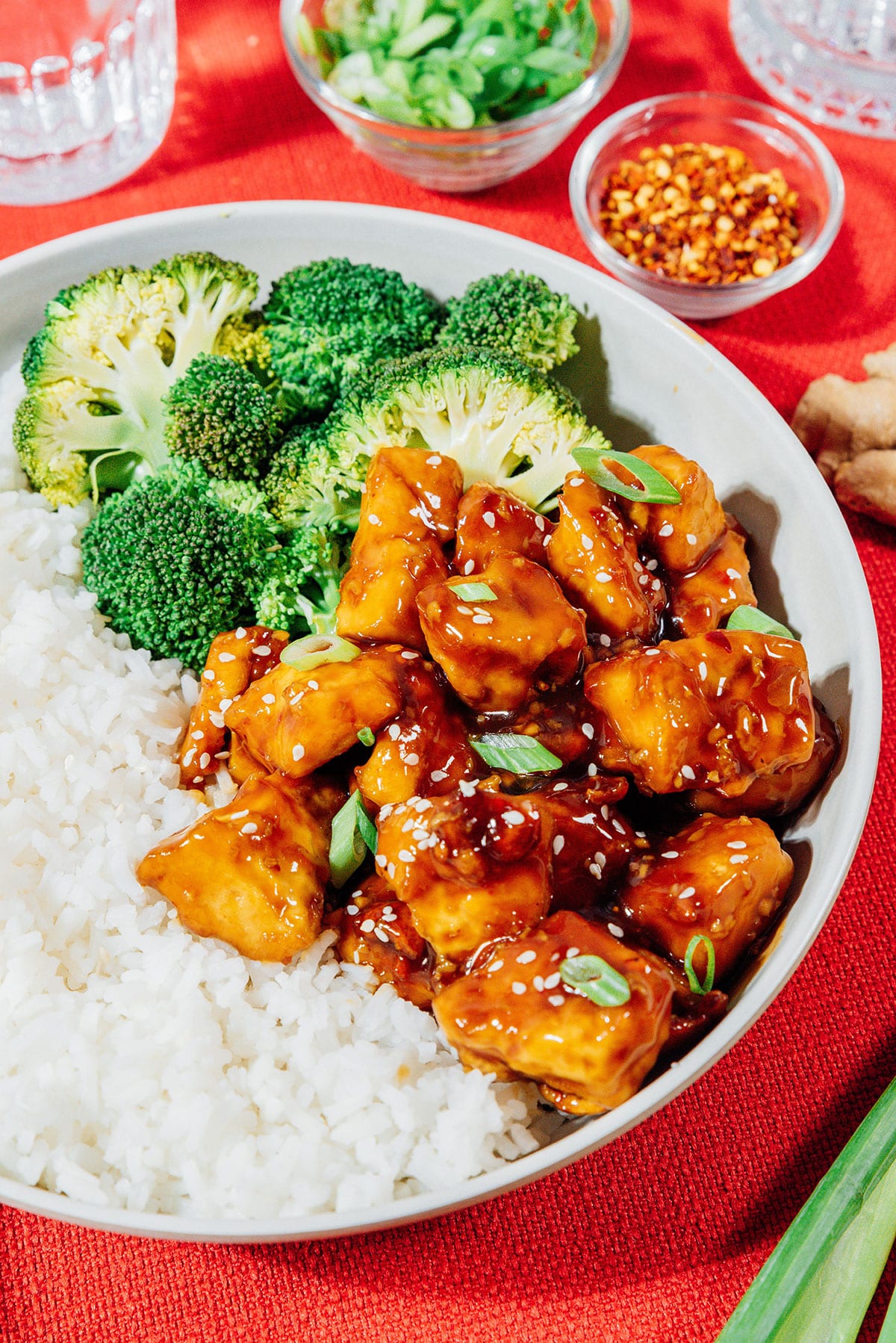 General tso's tofu in a bowl with rice and broccoli.