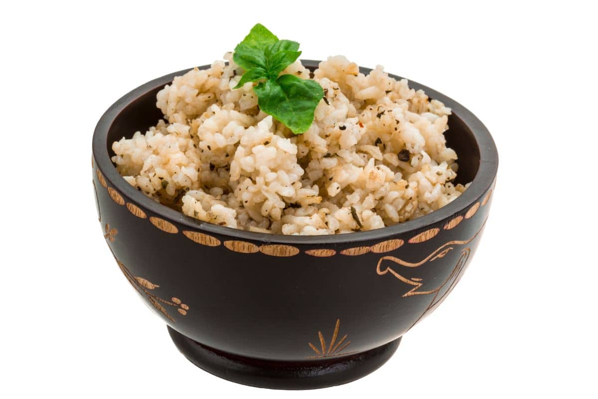 Glutinous brown rice in a wood bowl on a white background.