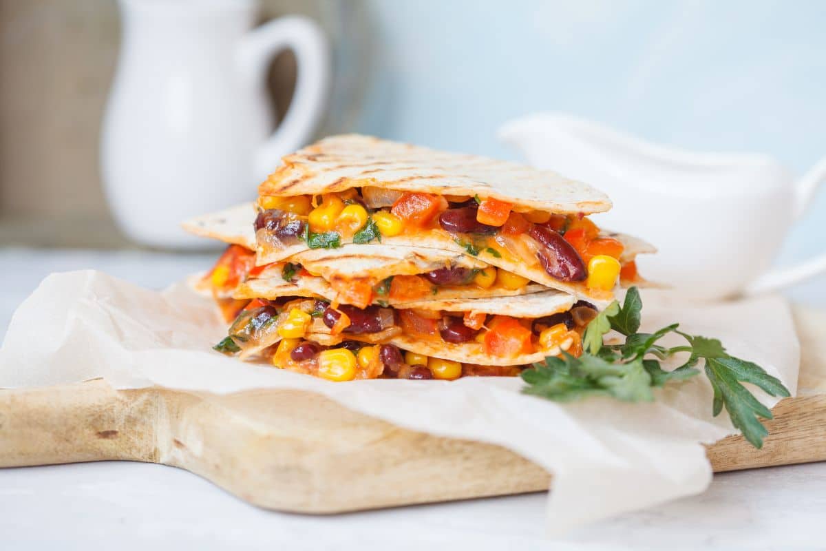 A stack of quesadillas with corn and black beans in them.