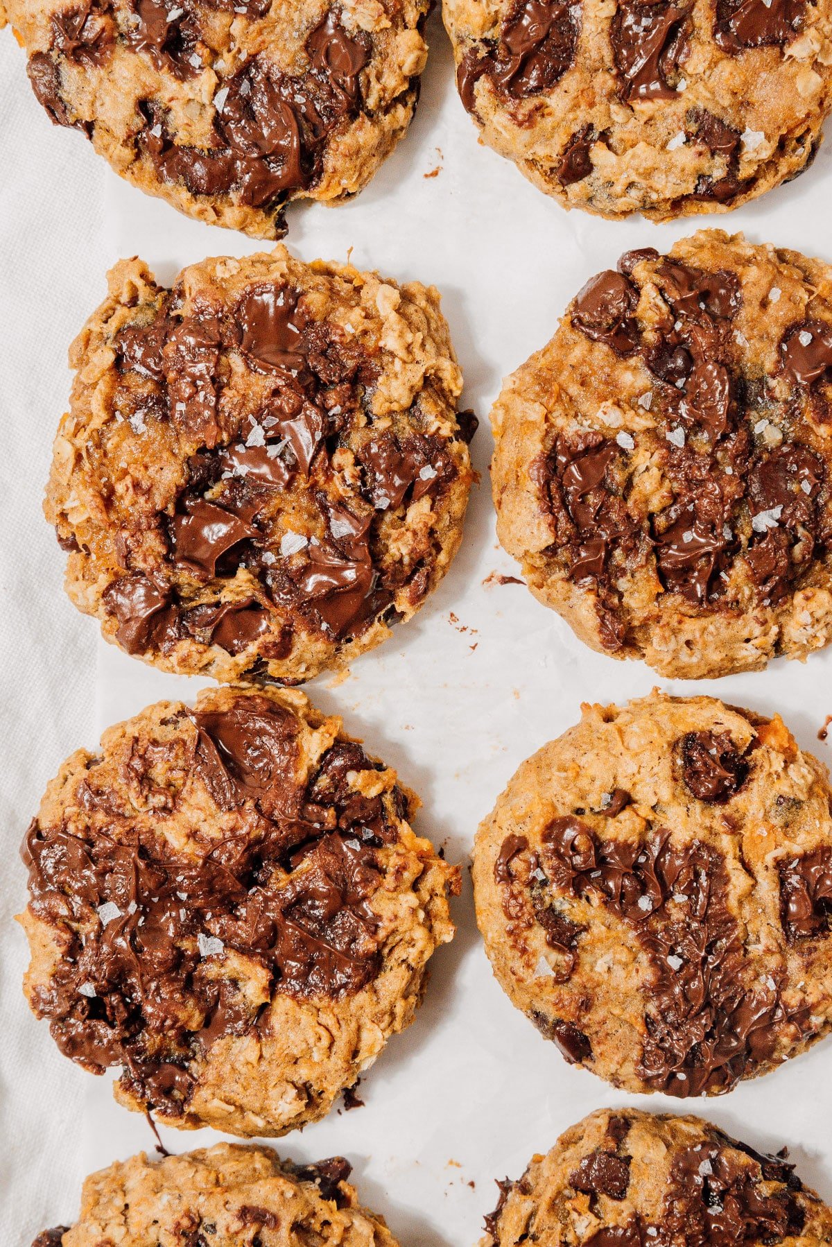 Sweet potato cookies with oats and chocolate on a white tablecloth.
