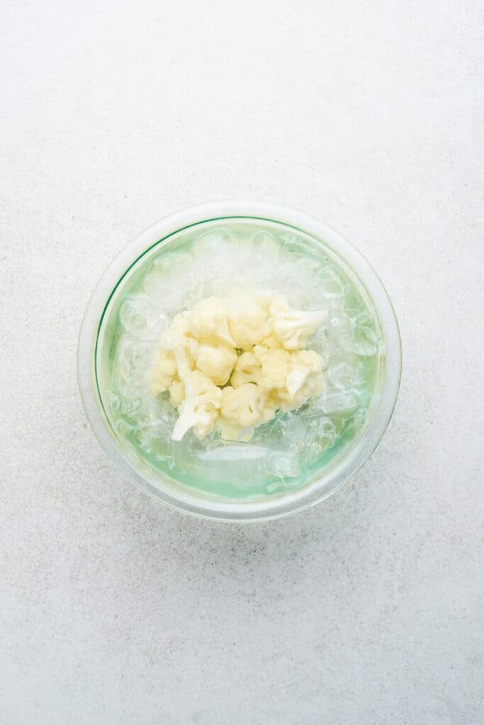 Blanched cauliflower in an ice bath.