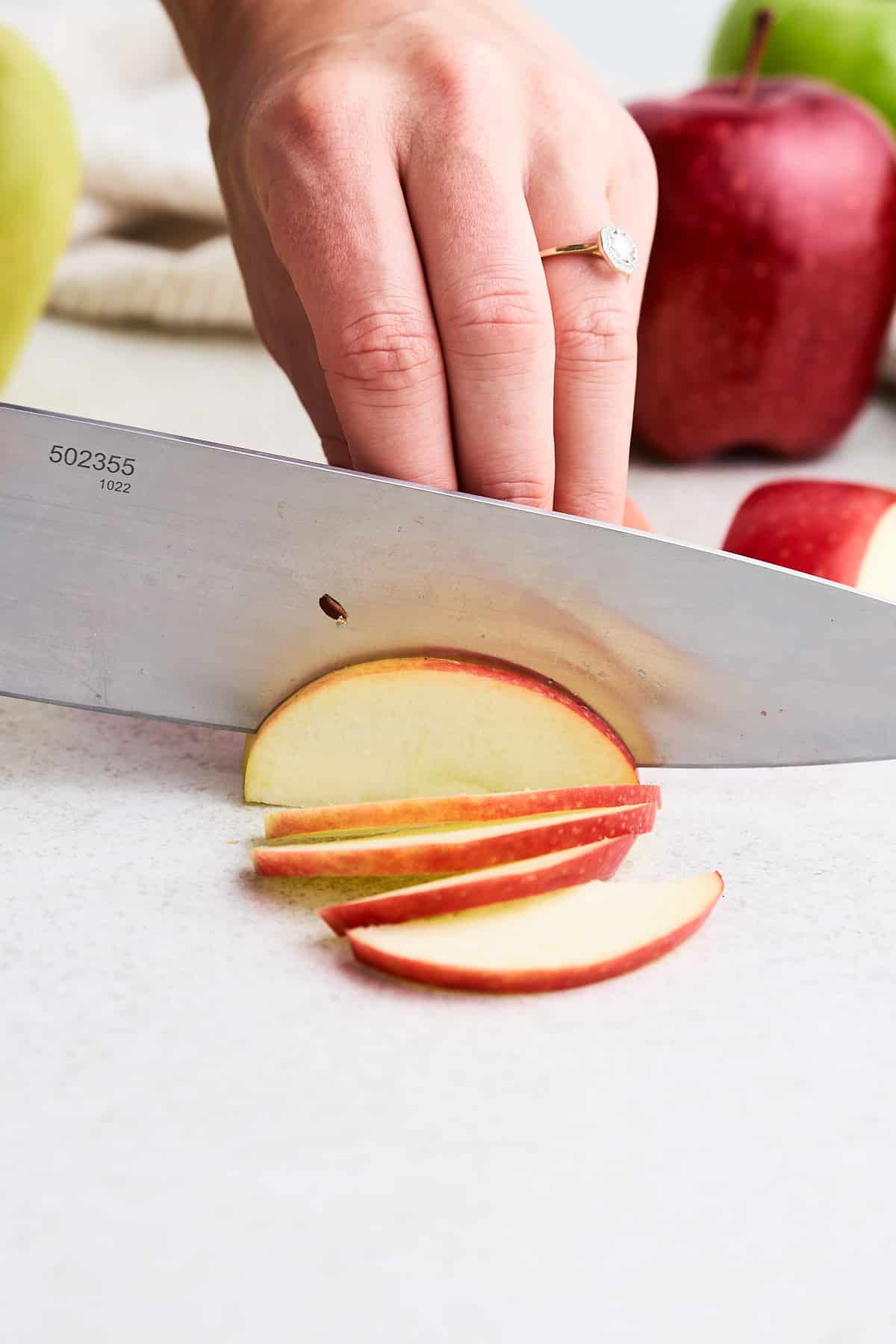 slicing an apple wedge into thin slices.