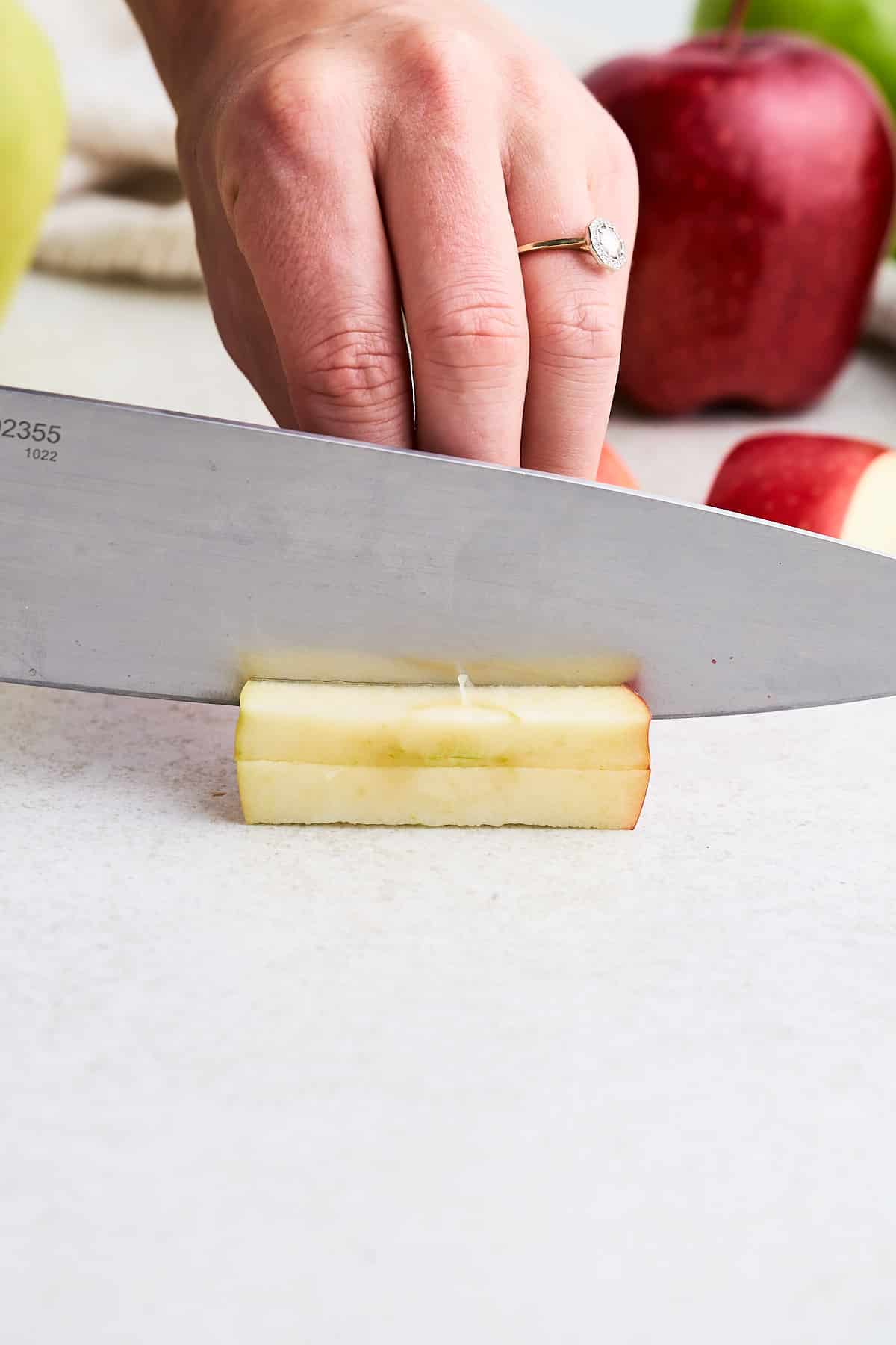 Cutting an apple into thick matchsticks.