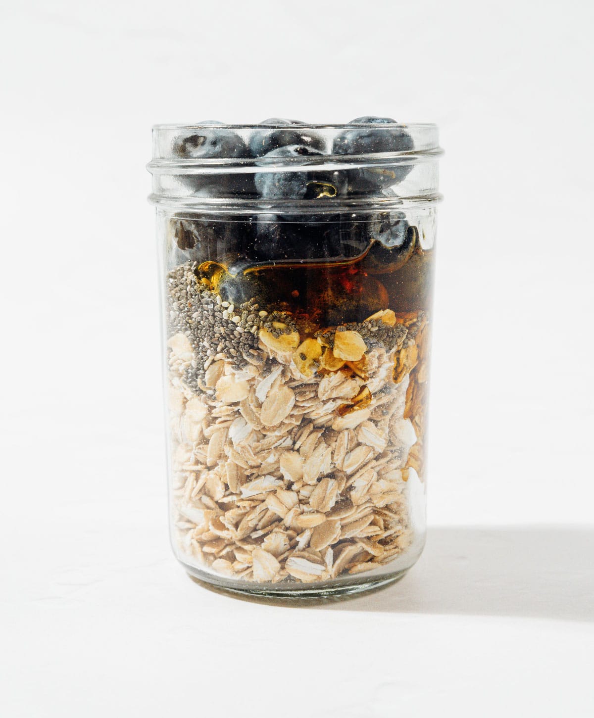 Ingredients for blueberry overnight oats in a jar.