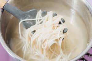 Udon noodles in a pot.