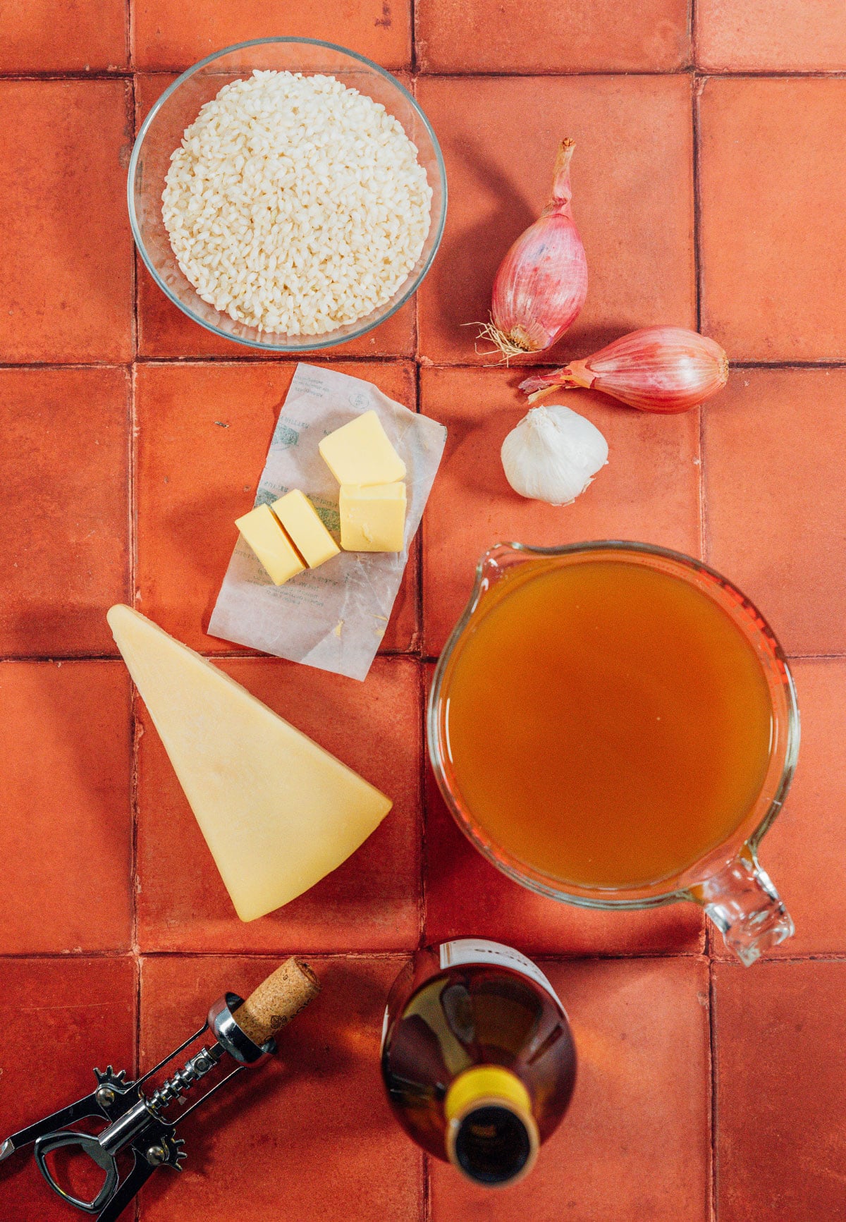 Ingredients for risotto on red clay tile.