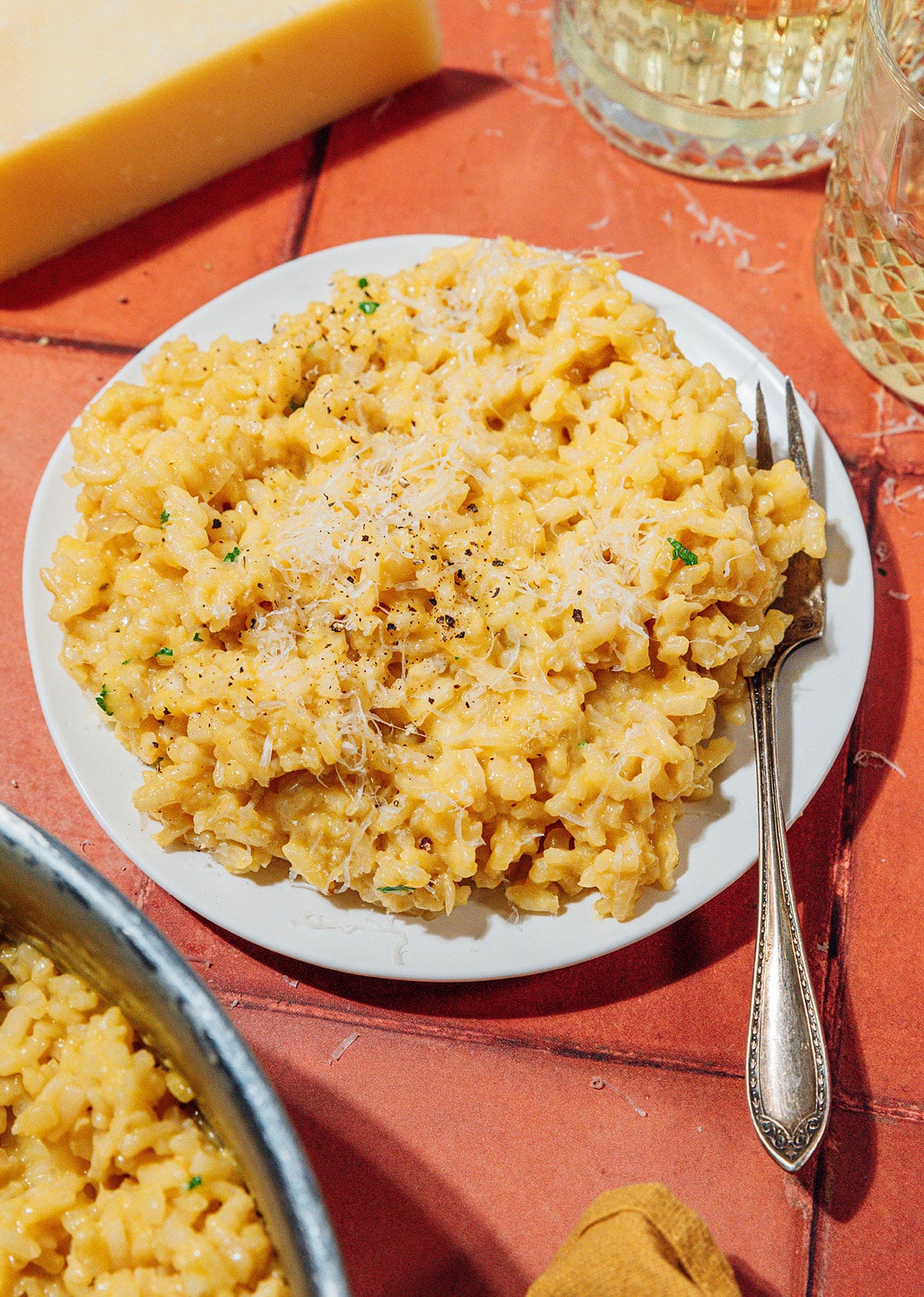 A plate of risotto on a orange background.