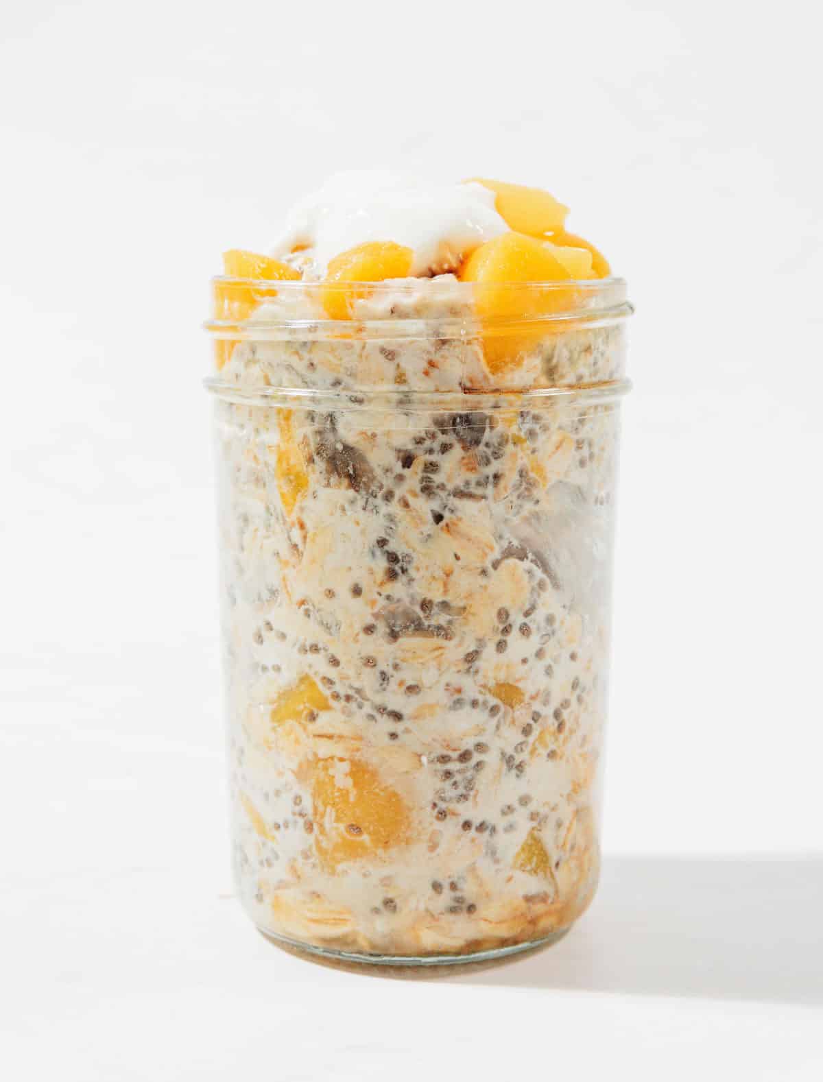 Ingredients for peach overnight oats in a jar.
