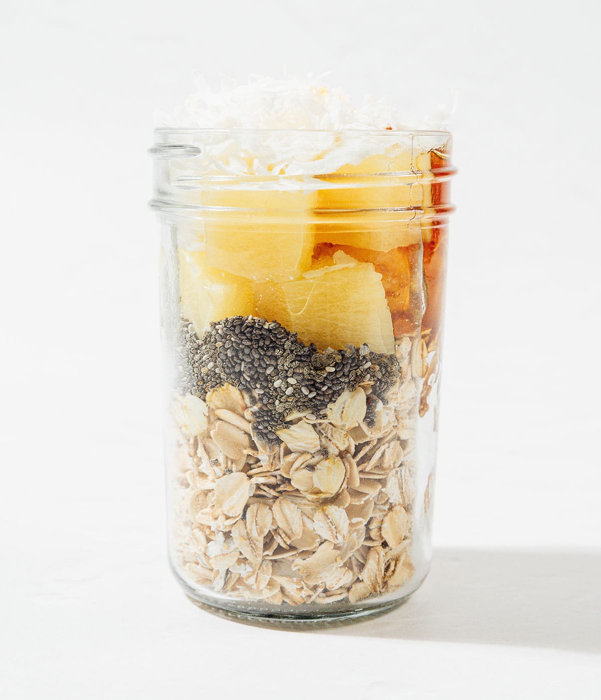 Ingredients for pineapple overnight oats in a jar.