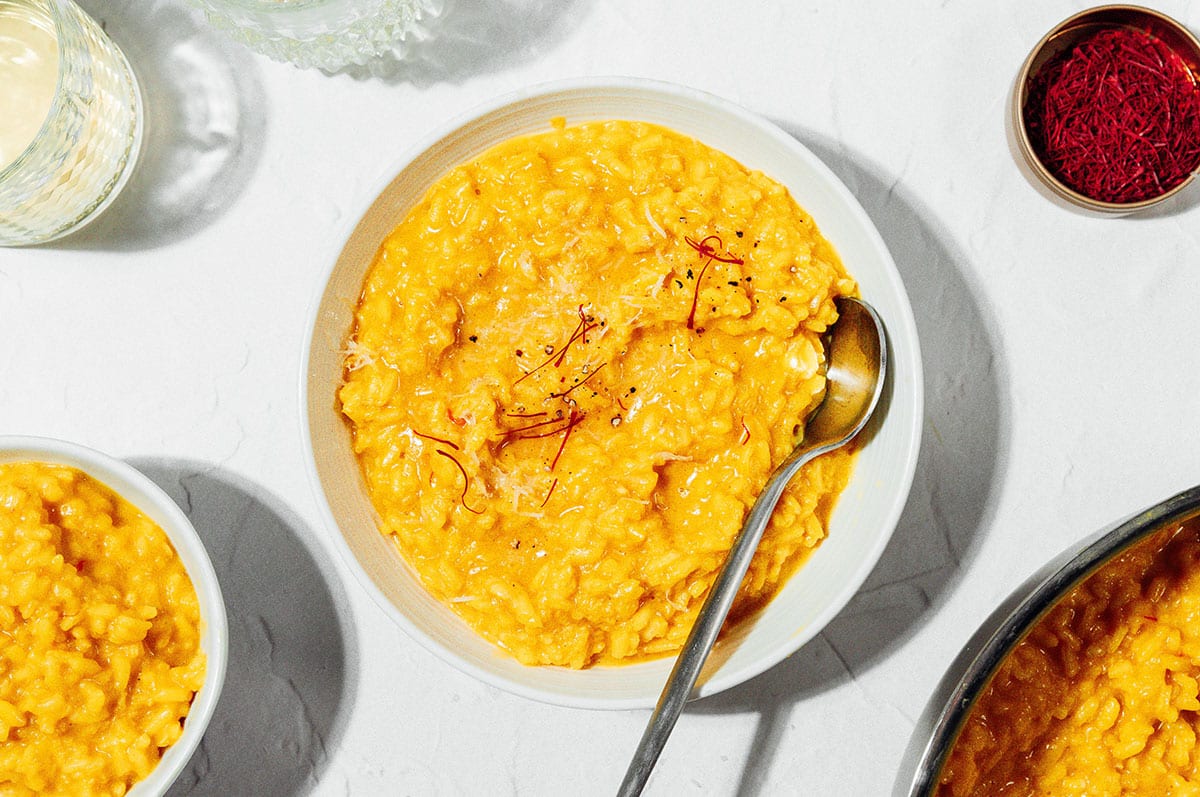Saffron risotto in a bowl with a spoon.