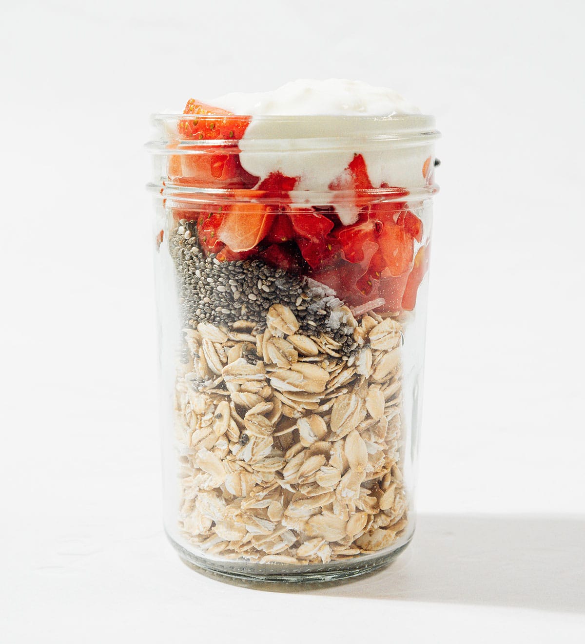 Ingredients for strawberry overnight oats in a jar.