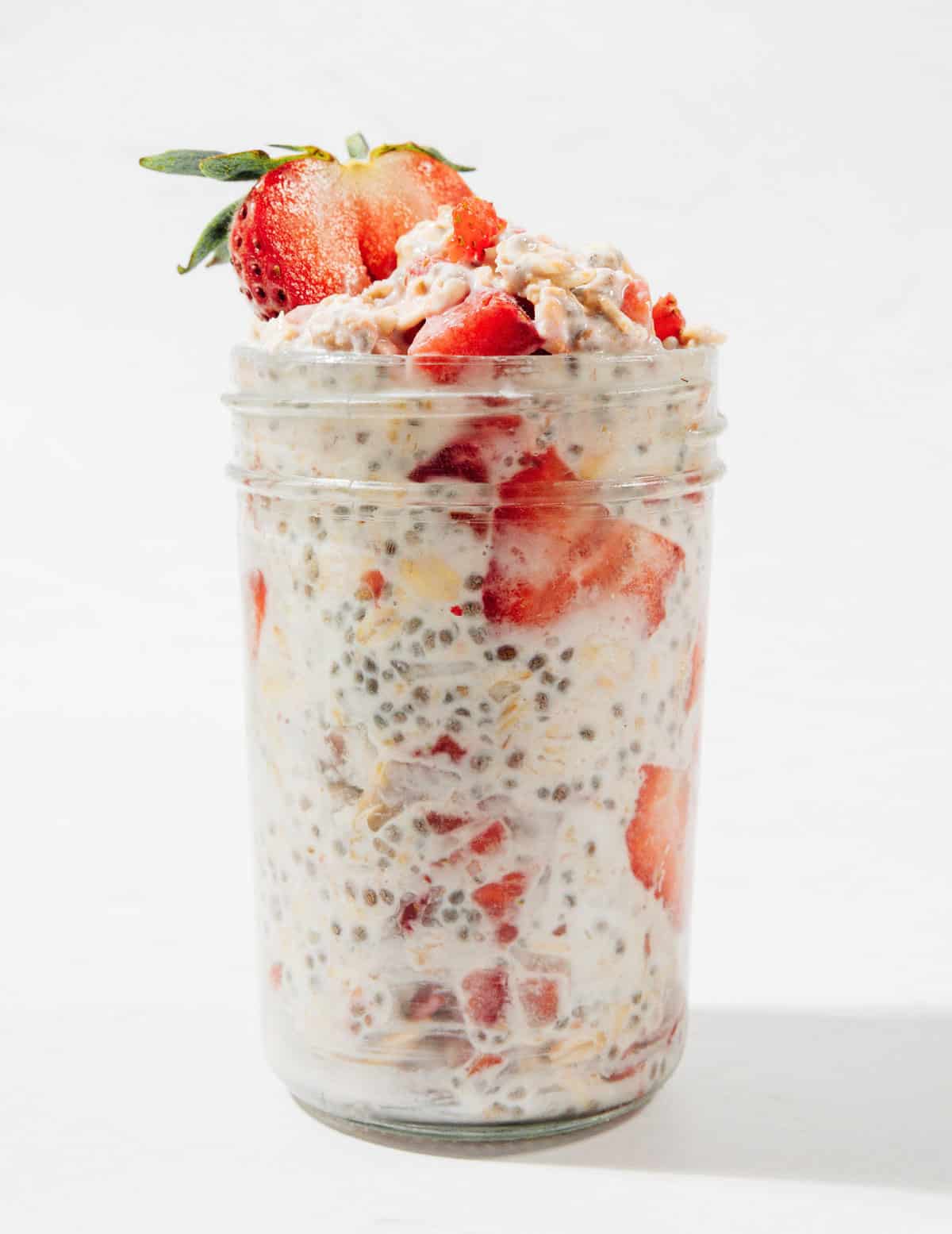 Ingredients for strawberry overnight oats in a jar.