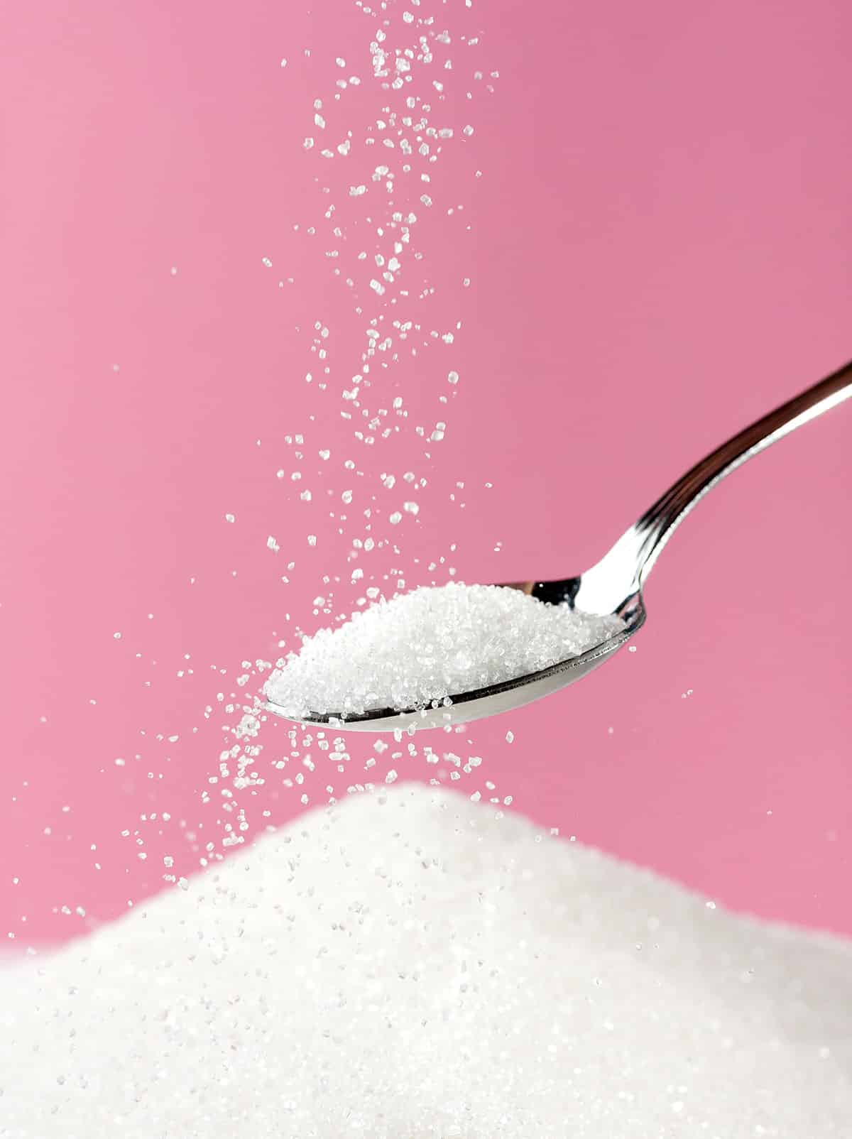 Sugar being poured onto spoon.