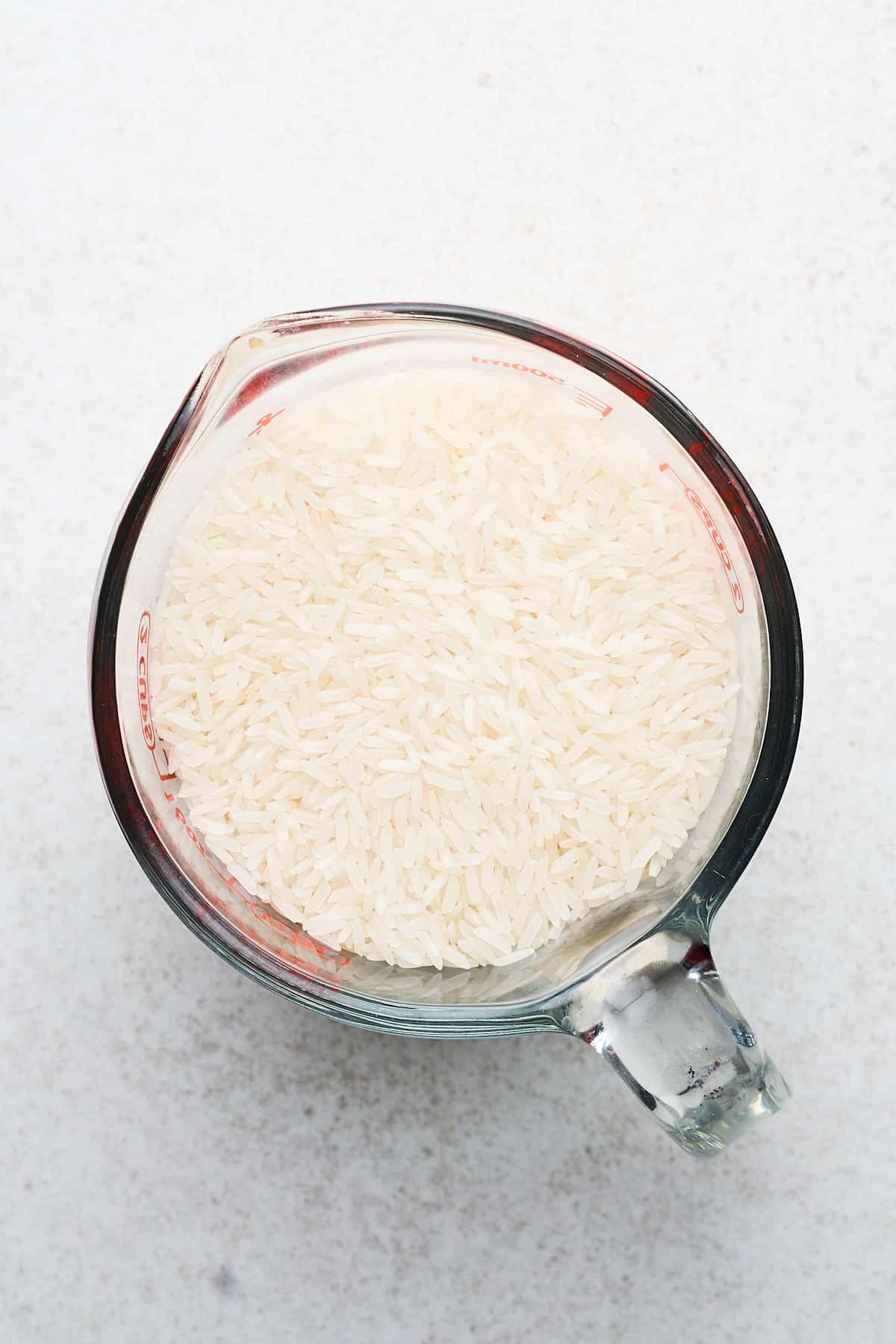 Jasmine rice in a measuring cup.