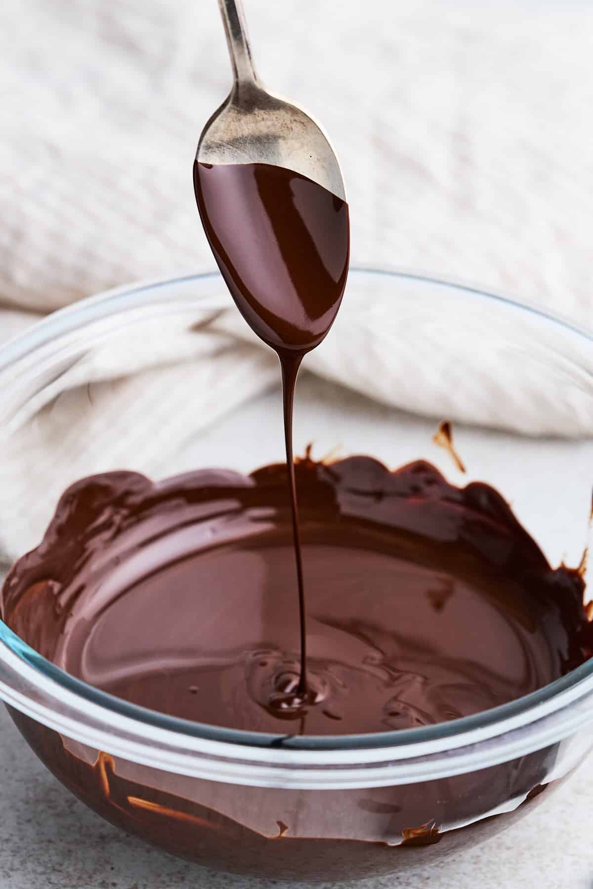 Drizzling melted chocolate into a bowl.